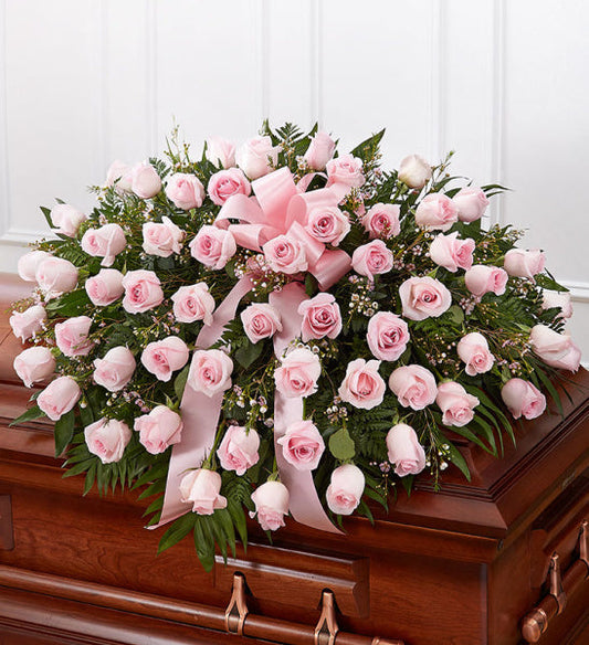Rose Half Casket in Pink, half casket spray with pink roses and mixed greenery accented with a pink ribbon