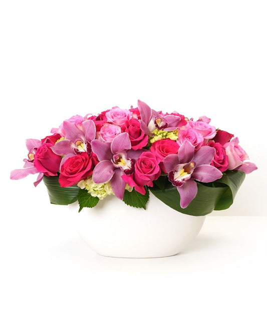 Product photo of Adoration floral arrangement with pink roses and orchids in a white bowl vase