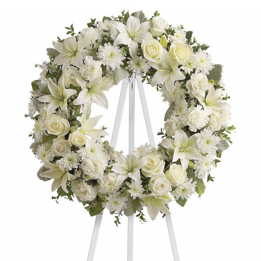 Serenity Wreath, funeral standing wreath with white roses, lilies, chrysanthemums, carnations, and mixed greenery