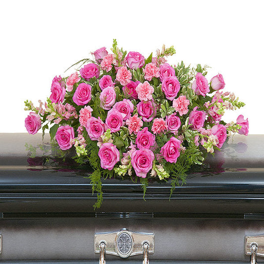  Peaceful Pink Casket Spray, half casket spray with pink roses, pink carnations, and mixed pink flowers accented with greenery