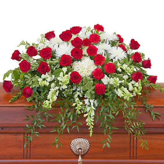 Enduring Strength Casket Spray, half casket spray with red roses, red carnations, white chrysanthemums, white hydrangeas, and mixed white flowers accented with greenery