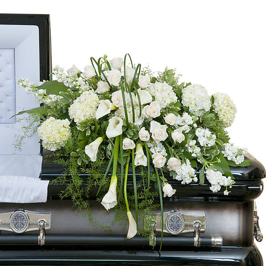 Elegant Love Casket Spray, half casket spray with white roses, calla lilies, hydrangeas, and mixed white flowers accented with greenery