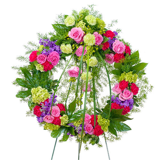 Forever Cherished Wreath Deluxe, funeral standing wreath with pink roses, carnations, green hydrangeas, purple statice, and mixed greenery