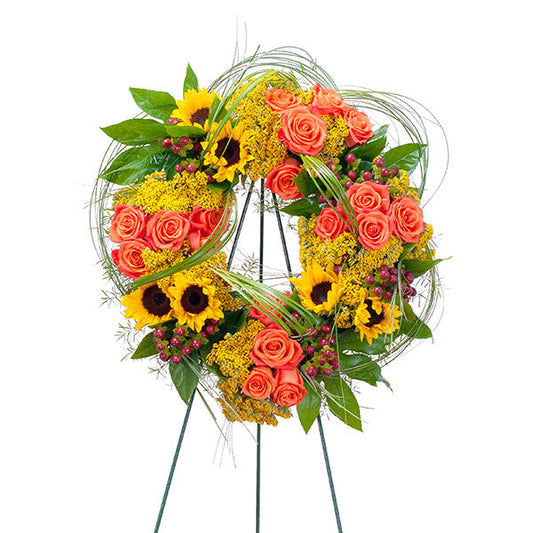 Heavens Sunset Wreath, funeral standing wreath with coral roses, sunflowers, and yellow solidago